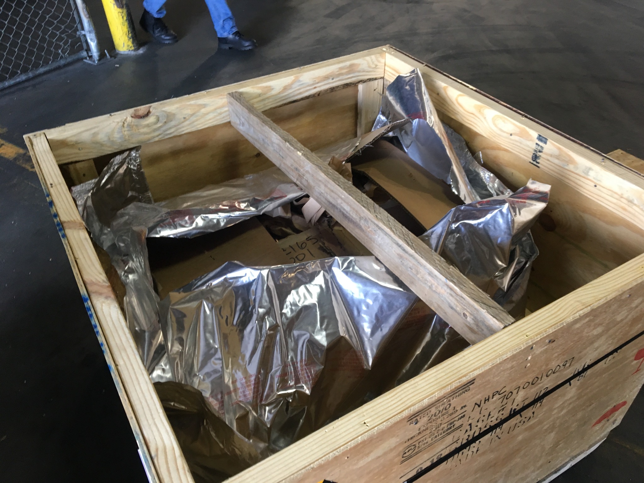 Foil barrier packaging fitted around machinery inside a crate