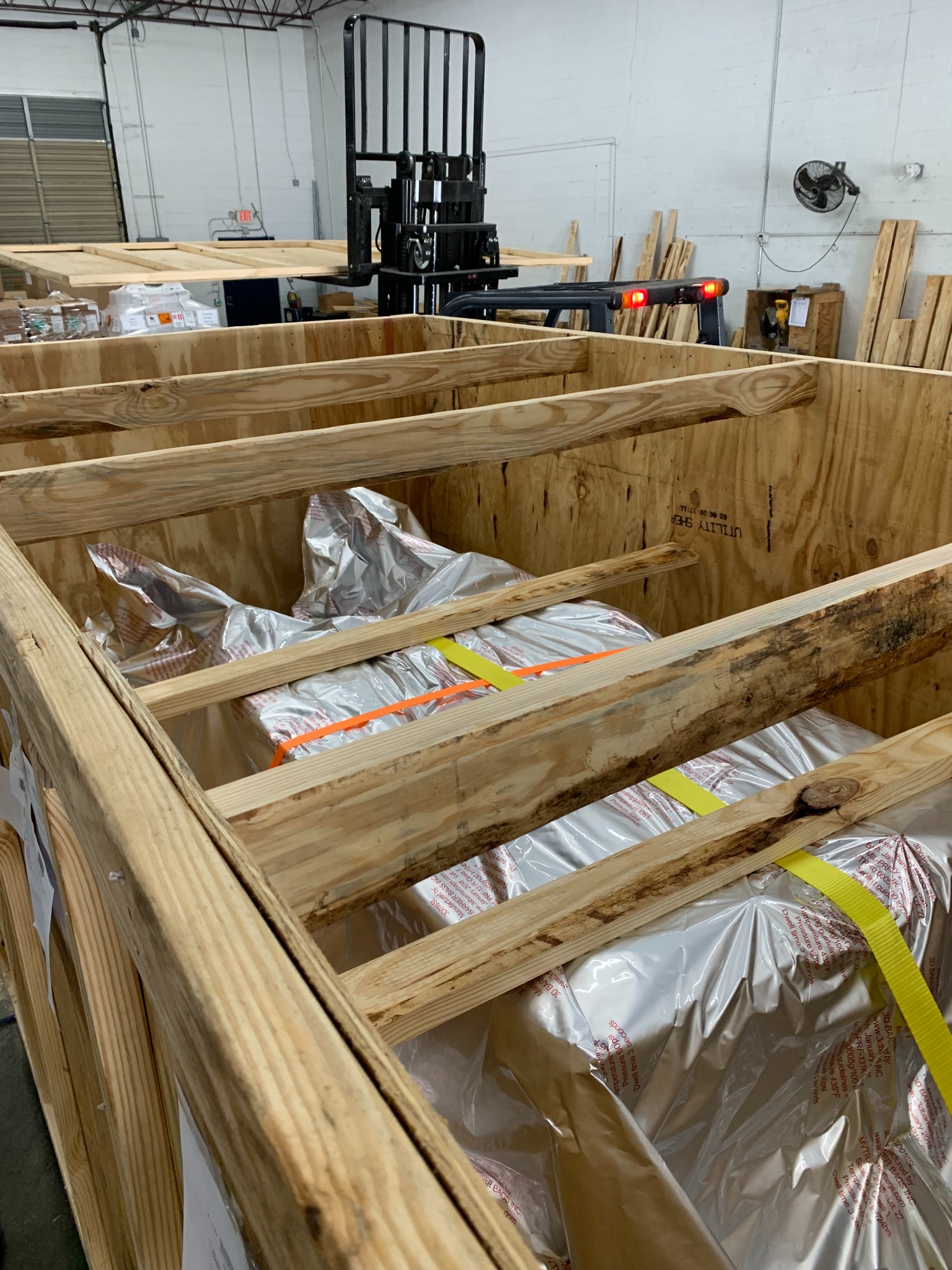Workers building the internal framing of a wooden crate