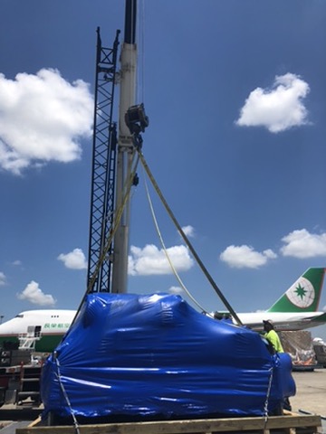 Oversize freight protected in blue industrial heat-shrink film at the airport