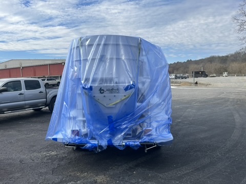 Trailer fully enclosed in blue heat-shrink film