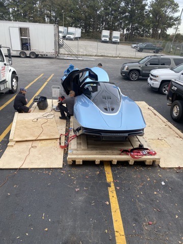 Blue McLaren secured to a custom vehicle shipping platform