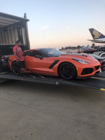 Sports car positioned beside a cargo aircraft